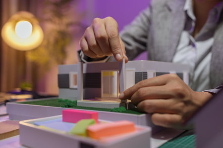 a passionate female architect works in her private office to remodel a house to meet her client's exact needs and meet construction deadlines, house model, engineer, blueprintの写真素材