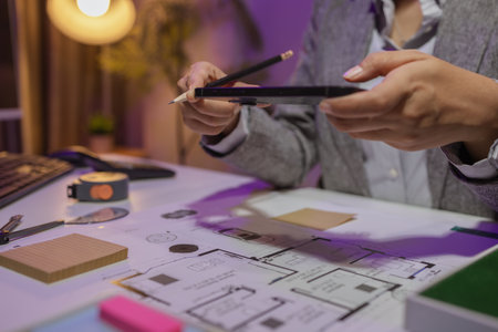 a beautiful female architect is working in her private office because she needs to concentrate on improving the blueprints to be in accordance with the law, engineer, foreman, contractorの写真素材