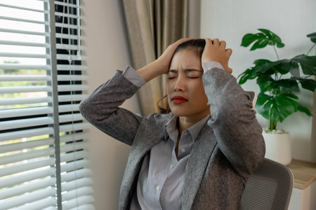 a female employee is extremely stressed at work, a businesswoman is stressed because the deadline for signing a contract is approaching but the documents are not yet completed, serious, upsetの写真素材