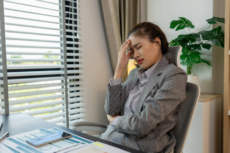 a female employee is extremely stressed at work, a businesswoman is stressed because the deadline for signing a contract is approaching but the documents are not yet completed, serious, upsetの写真素材