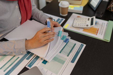 a muslim company employee works in a large financial organization, a muslim female entrepreneur is reviewing her company's financial documents, marketing, accountant, hijab, islamの写真素材