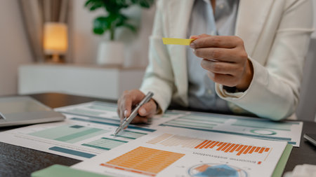 the document reviewer is comparing the information to match the meeting minutes to be presented to investor, businessman is working in finance, accountant, marketing, businesswomanの写真素材