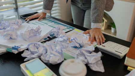 a female employee is extremely stressed at work, a businesswoman is stressed because the deadline for signing a contract is approaching but the documents are not yet completed, serious, upsetの写真素材