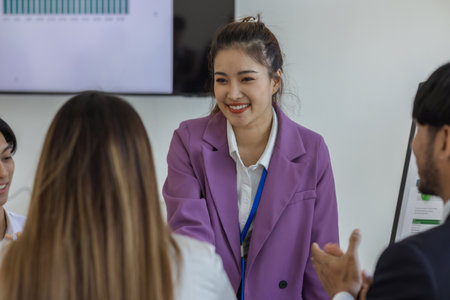 after the businessmen successfully agreed to the merger and signed the contract and they shook hands to express their congratulations, the marketing and accounting departments were shaking handsの写真素材