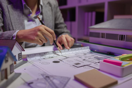 a beautiful female architect is working in her private office because she needs to concentrate on improving the blueprints to be in accordance with the law, engineer, foreman, contractorの写真素材