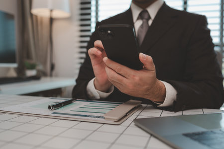 a businessman is studying information in a document to gain a better understanding, a department head is reviewing statistical documents sent by his subordinates, accountant, officeの写真素材