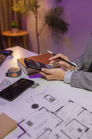a beautiful female architect is working in her private office because she needs to concentrate on improving the blueprints to be in accordance with the law, engineer, foreman, contractorの写真素材