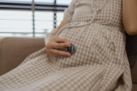 a pregnant mother is relaxing on a sofa in her own home, a woman's pregnancy, family, a woman was very happy because she was pregnant and would soon give birth to her babyの写真素材