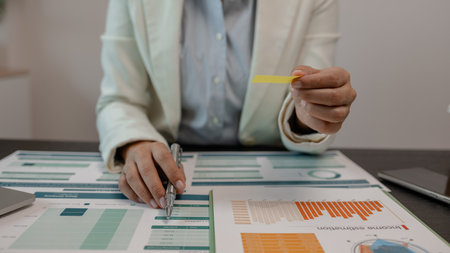 the document reviewer is comparing the information to match the meeting minutes to be presented to investor, businessman is working in finance, accountant, marketing, businesswomanの写真素材