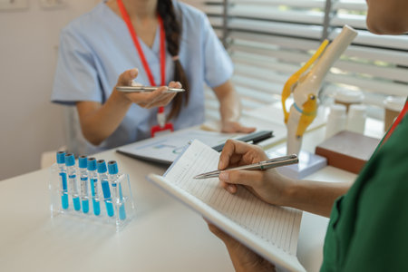 consultation between two doctors in the office, two medical students are discussing treatment guidelines for a patient assigned to them by a senior physician, nurse, brainstorming, hospitalの写真素材