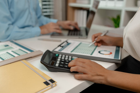 the company's statistics department staff is checking the figures form the graph in the document for recording, accounting, finance, marketing, entrepreneur, paperwork, officeの写真素材