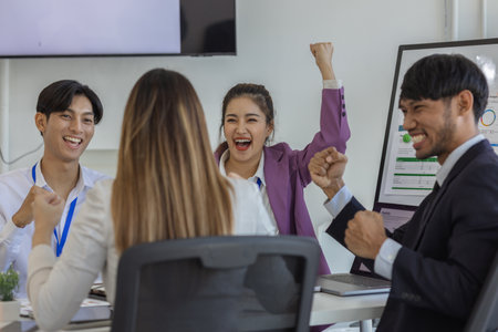businesspeople show their joy by clapping or expressing their facial expressions by shouting 'yes' because the project is successful, employees are happy that the meeting went well, cheerful, joyfulの写真素材