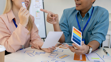 ux, ui, web and mobile app designers are discussing the look and feel of the website or app they are designing including color schemes and layouts to make it easy and enjoyable for usersの写真素材