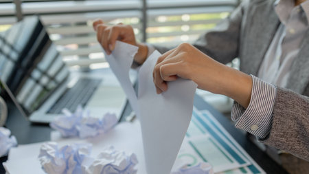 a female employee is extremely stressed at work, a businesswoman is stressed because the deadline for signing a contract is approaching but the documents are not yet completed, serious, upsetの写真素材