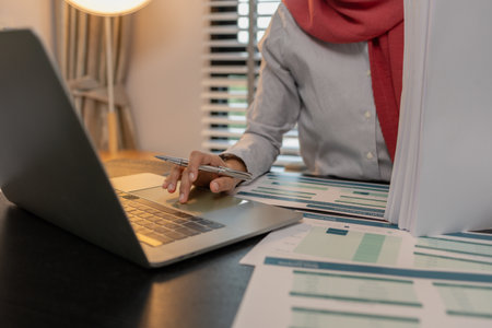 a muslim female entrepreneur is reviewing her company's financial documents, marketing, accountant, hijab, islam, a muslim company employee works in a large financial organizationの写真素材