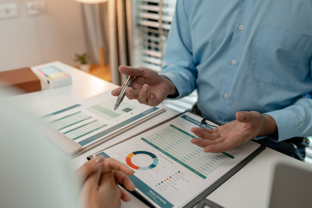 the company's auditing staff is checking the documents for accuracy in the office, businessman is explaining information in a document to his partner, graph, entrepreneur, marketingの写真素材