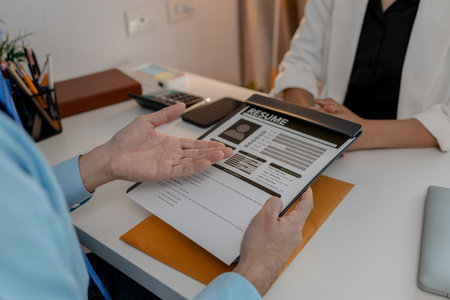 the head of human resources at an accounting firm is interviewing a candidate for a marketing position, resume, recruitment, hr, job interview, he submits his resume to the HR department in the officeの写真素材
