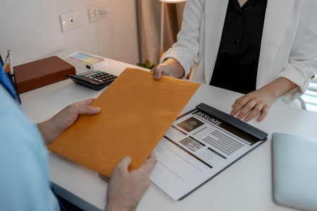 the head of human resources at an accounting firm is interviewing a candidate for a marketing position, resume, recruitment, hr, job interview, he submits his resume to the HR department in the officeの写真素材