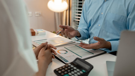 the company's statistics department staff is checking the figures form the graph in the document for recording, accounting, finance, marketing, entrepreneur, paperwork, officeの写真素材
