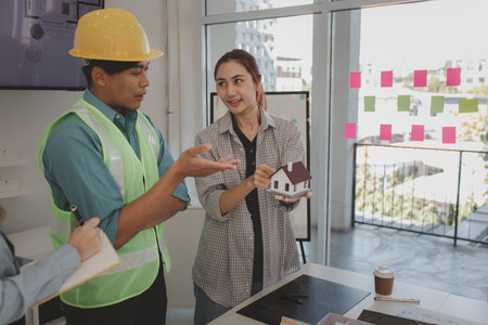 architects and engineers are discussing the design and structure of the upcoming building with the foreman to ensure that they understand the details on the same page, brainstorming, blueprintの写真素材