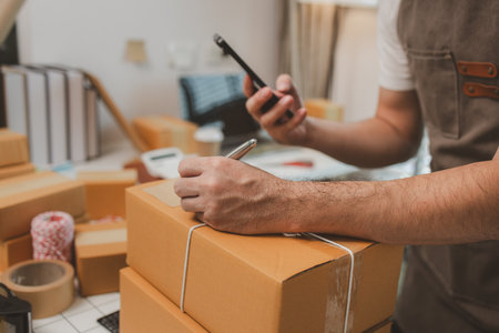 he is checking the boxes in the packing room, a small business owner is preparing boxes to ship to customers, product, e-business, entrepreneurs in online sales and export businessesの写真素材
