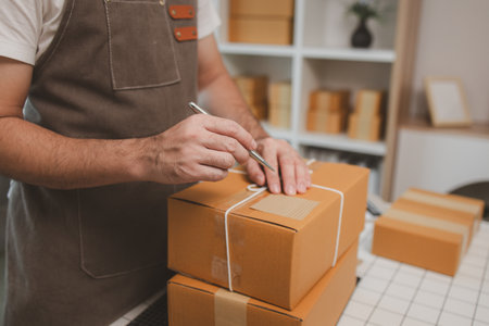 he is checking the boxes in the packing room, a small business owner is preparing boxes to ship to customers, product, e-business, entrepreneurs in online sales and export businessesの写真素材