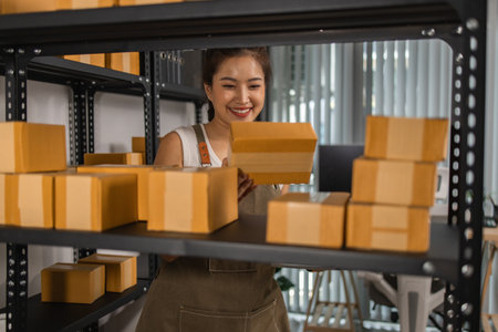a packer checks the condition of a package before it is delivered to a customer, a small business owner inspects boxes in a warehouse, a storage room filled with shelves and parcelの写真素材
