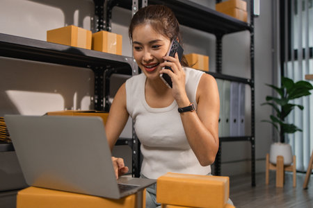 warehouse worker is checking boxes of packaged in the warehouse, a small business owner who runs an online business is packing packages to send to customers, parcel, e-business,の写真素材