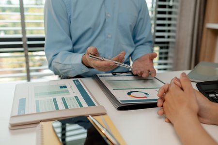 the company's statistics department staff is checking the figures form the graph in the document for recording, accounting, finance, marketing, entrepreneur, paperwork, officeの写真素材