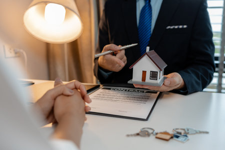 staff is explaining the information about the house lease contract documents to the buyer, the buyer signs the house lease agreement acknowledgment contract with the staff to transfer the ownershipの写真素材