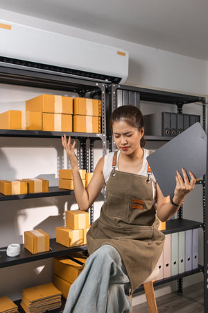 an online business owner shows signs of stress due to a high volume of returned packages from customers, an employee working in a warehouse is stressed due to overwork, parcel, package, storageの写真素材