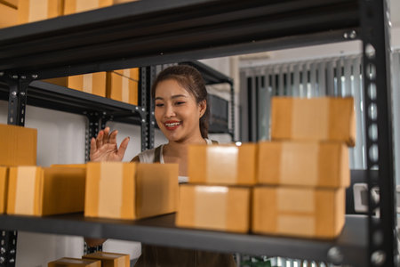 a packer checks the condition of a package before it is delivered to a customer, a small business owner inspects boxes in a warehouse, a storage room filled with shelves and parcelの写真素材