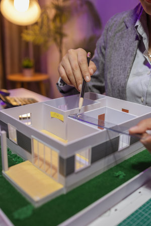 a passionate female architect works in her private office to remodel a house to meet her client's exact needs and meet construction deadlines, house model, engineer, blueprintの写真素材