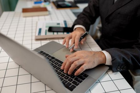 a businessman is sitting at work in his private office, an employee is handling documents to finish on time, accountant, finance, statistics documents, professional, workplaceの写真素材