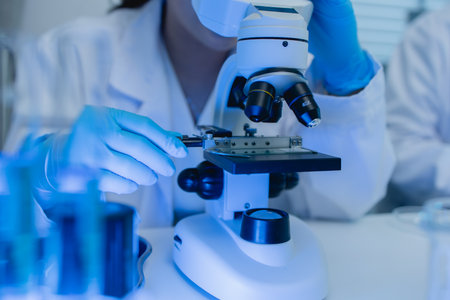two scientists are working together to find a new antiviral drug, two chemists are using scientific tools to study science, microscope, working in the lab, researchers' work in the laboratoryの写真素材