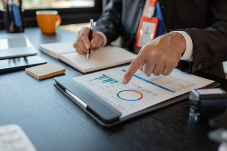 a businessman reviews the company's financial documents in his office, the accountant is rushing to check the figures in the documents before submitting them to the tax officeの写真素材