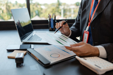 a businessman reviews the company's financial documents in his office, the accountant is rushing to check the figures in the documents before submitting them to the tax officeの写真素材