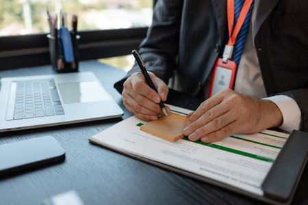 a businessman is reviewing accounting and financial statistics documents in his private office, the statistician prepares various charts and documents for a meetingの写真素材