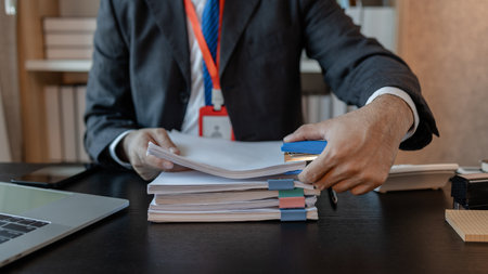 an accounting and financial officer is working on documents in the office, a businessman is reviewing his company's historical budget statistics, finance, marketingの写真素材