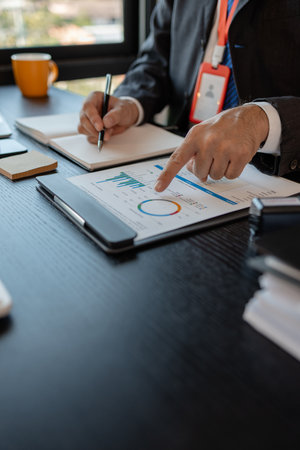an accounting and financial officer is working on documents in the office, a businessman is reviewing his company's historical budget statistics, finance, marketingの写真素材