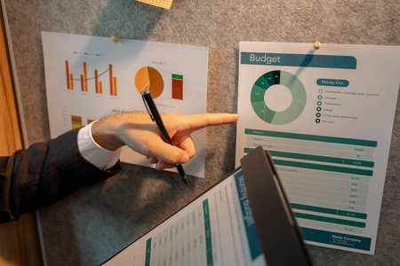 chart-based statistical data is prepared by accounting staff to present the company's income and expenditure data, a businessman prepares marketing and financial information for presentationの写真素材