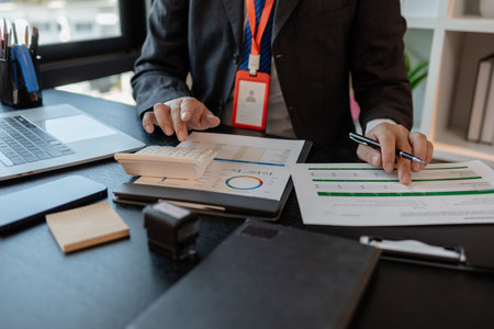 a businessman reviews the company's financial documents in his office, the accountant is rushing to check the figures in the documents before submitting them to the tax officeの写真素材