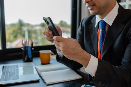a businessman woks with a foreign company and uses a smartphone to help send and receive information, marketing manager sends statistic information to accounting department via a smartphoneの写真素材