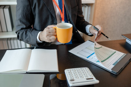 an accounting and financial officer is working on documents in the office, a businessman is reviewing his company's historical budget statistics, finance, marketingの写真素材