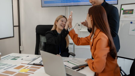 the group of business people showed their joy by clapping and giving high fives because of their success in business, joyful, cheerful, brainstorming in the meeting room, businessmanの写真素材
