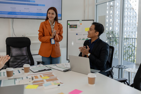 the group of business people showed their joy by clapping and giving high fives because of their success in business, joyful, cheerful, brainstorming in the meeting room, businessmanの写真素材