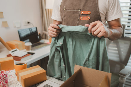 a small online business owner is checking boxes for accuracy before shipping to customers, parcel,...