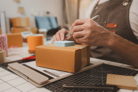 a small online business owner is checking boxes for accuracy before shipping to customers, parcel, an employee is packing products into boxes to prepare for shipping to customersの写真素材