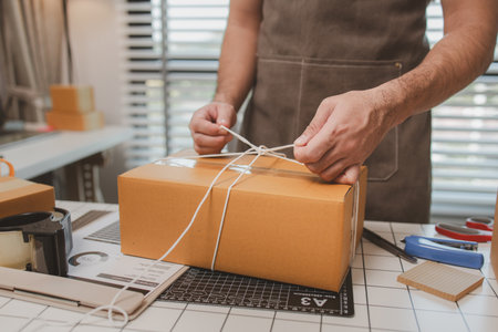 an employee is packing products into boxes to prepare for shipping to customers, a small online business owner is checking boxes for accuracy before shipping to customers, parcel,の写真素材