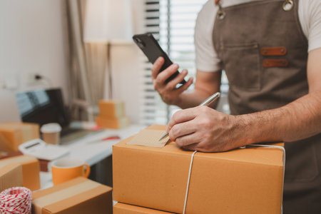 he is checking the boxes in the packing room, a small business owner is preparing boxes to ship to...